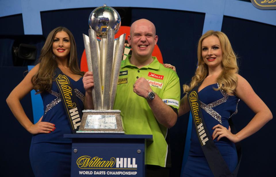 Harper stands next to Michael van Gerwen (on the left) as he picks up yet more silverware