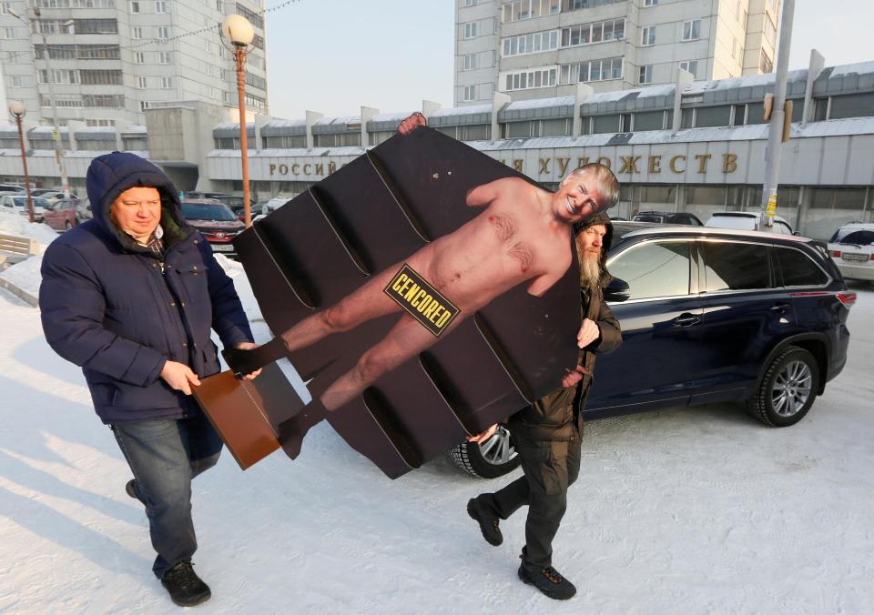 Russian artist Vasily Slonov (left) was seen carrying this life-sized cutout of Trump