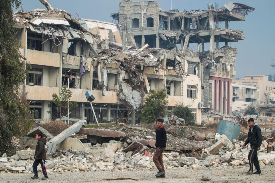 An Iraqi boys walk near the University of Mosul after its liberation from ISIS