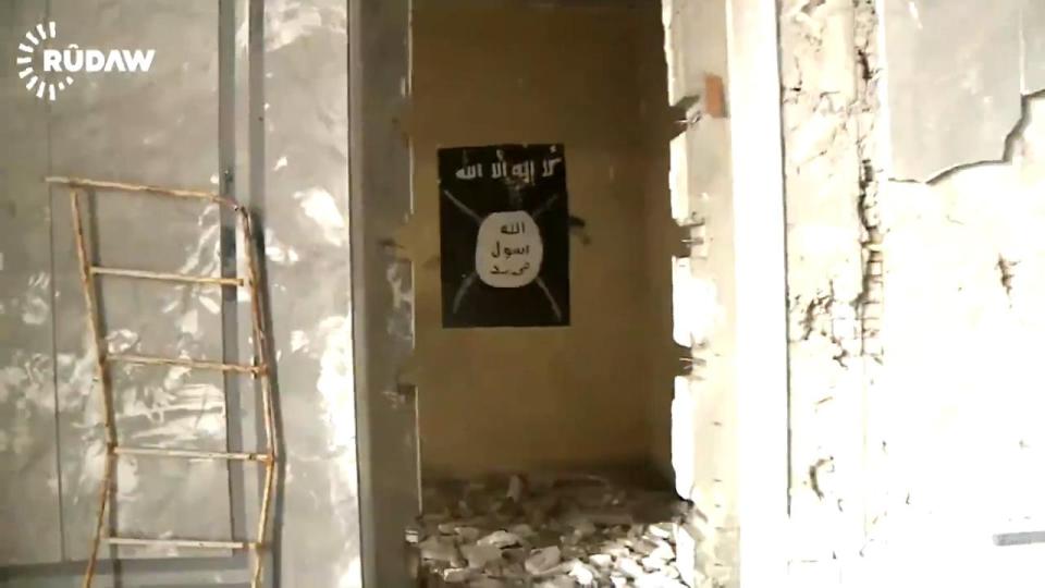 An ISIS flag adorns a wall