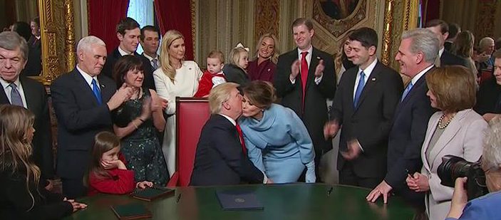 Melania was pictured kissing Trump on the cheek during the signing of the documents 