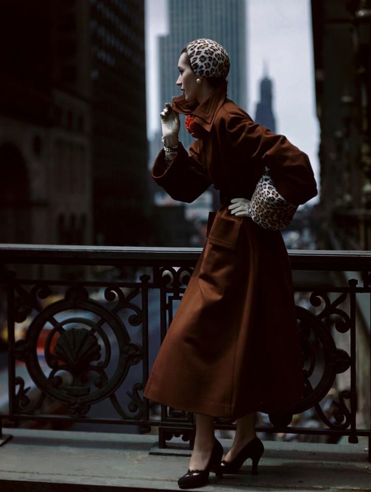  A model dressed in a burnt orange trench coat, a leopard print hat and black heels is photographed posing on an ornate balcony (Norman Parkinson, Glamour, October 1949 © Norman Parkinson Limited. Courtesy Norman Parkinson Archive)