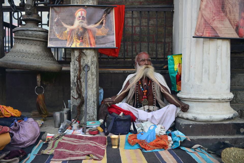  An elderly sadhu is pictured stretching his beard out