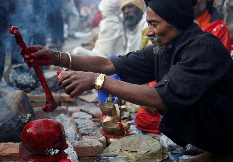  One worshipper offers prayers on a human skull painted red