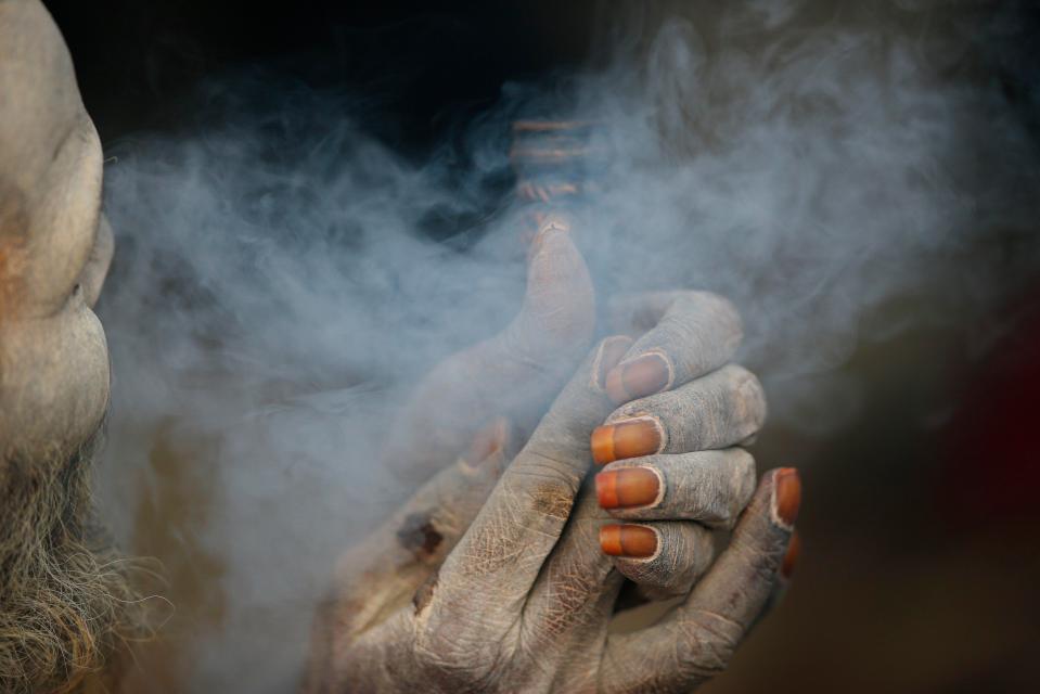  A Hindu man smokes his clay pipe at the festival