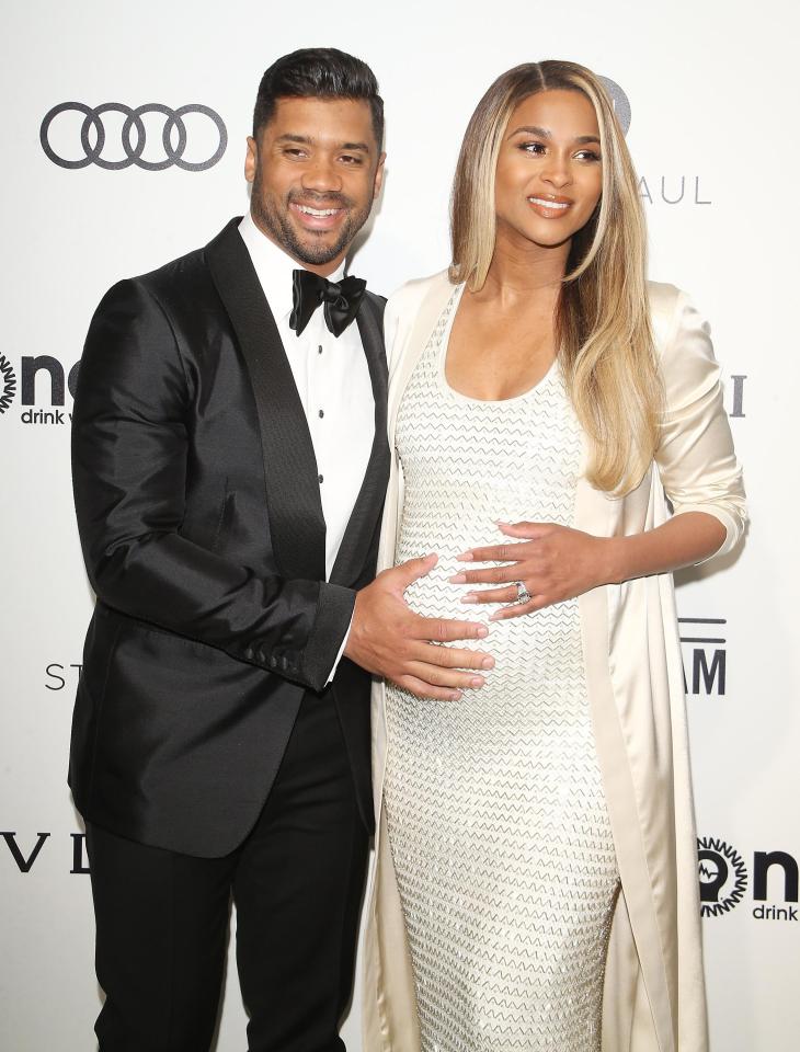 Her husband Russell Wilson cradled the bump in front of photographers