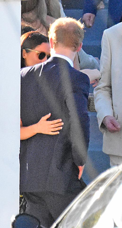 The couple were clearly comfortable in public with each other with Meghan seen putting her hand on Prince Harry's back