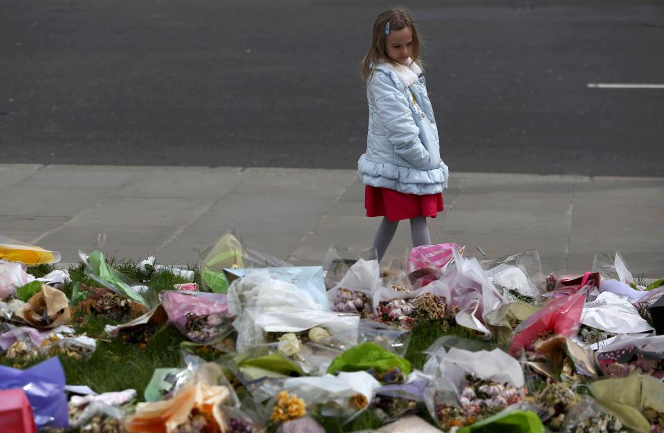  A young girl looks at the tributes to PC Palmer at Westminster ahead of his funeral today