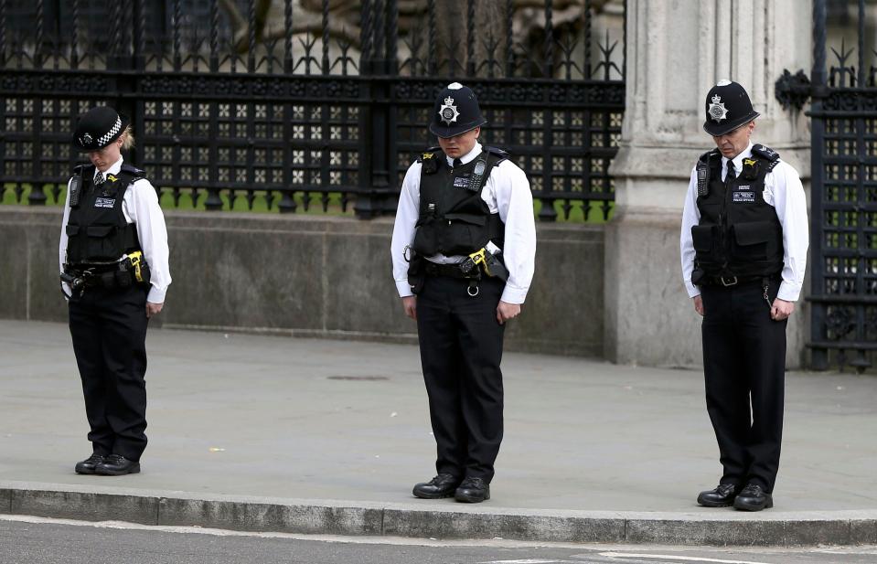  Police officers stand respectfully as the hearse containing PC Palmer moves off to Westminster