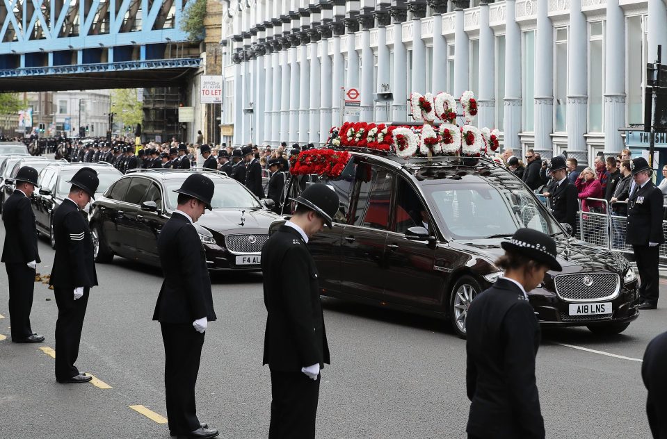  Officers, some of whom have travelled from all over the country to pay their respects, bow their heads as the hearse drives past