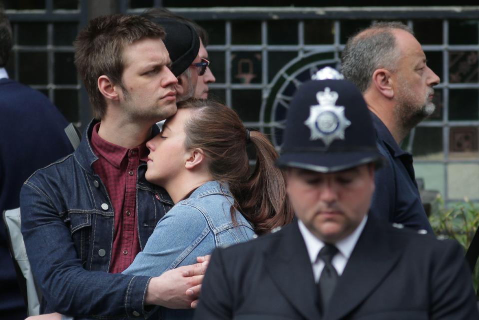  A couple embrace as they stand amongst the crowd paying their respects to PC Palmer
