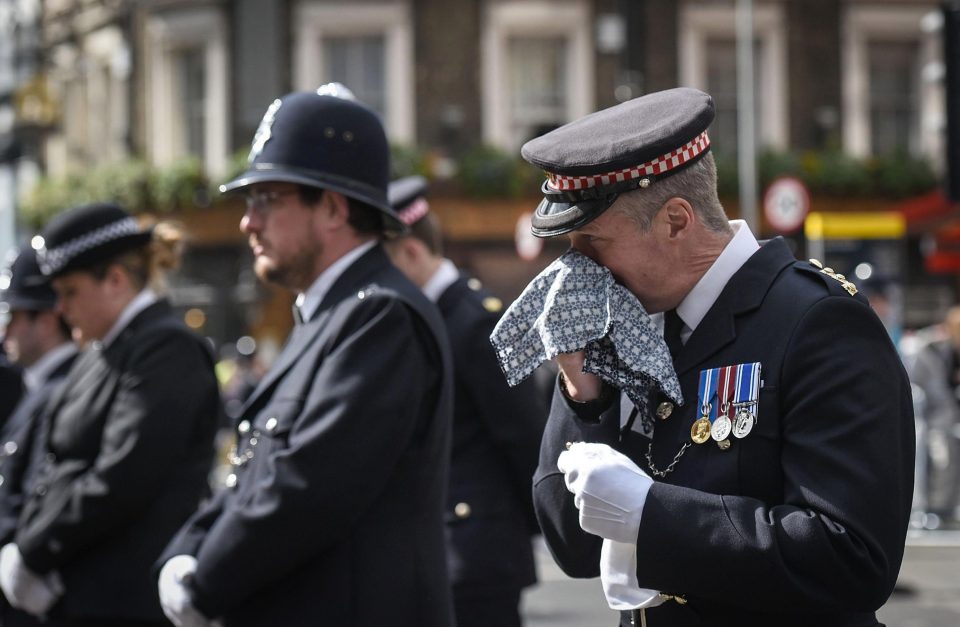  A police officer wipes away tears as he listens to the emotional funeral service for PC Palmer