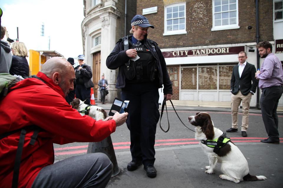  One police dog on patrol at the funeral procession is photographed by onlookers