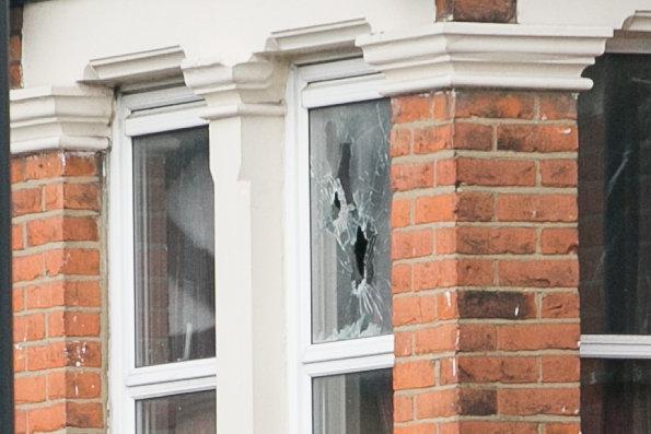 Holes in the upstairs window of the property in Willesden
