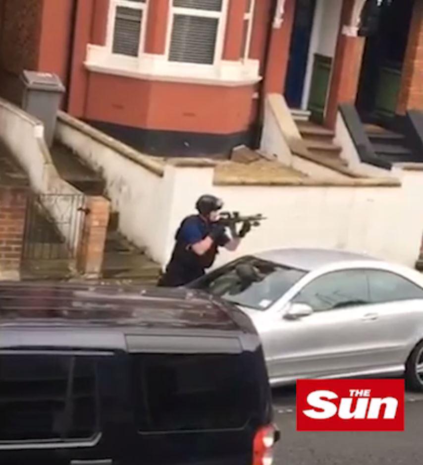 An armed cop is sen during a police raid in Willesden, northwest London
