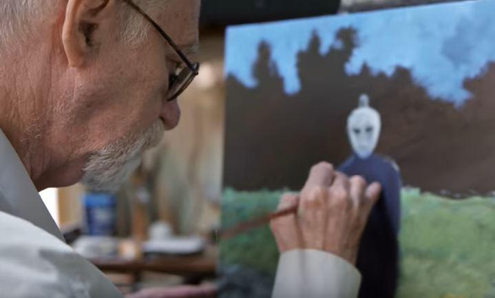  A grab from the film Love And Saucers shows Huggins working on an alien painting
