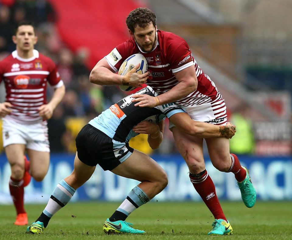 Wigan's Sean O'Loughlin is tackled by Jayden Brailey of Cronulla-Sutherland Sharks