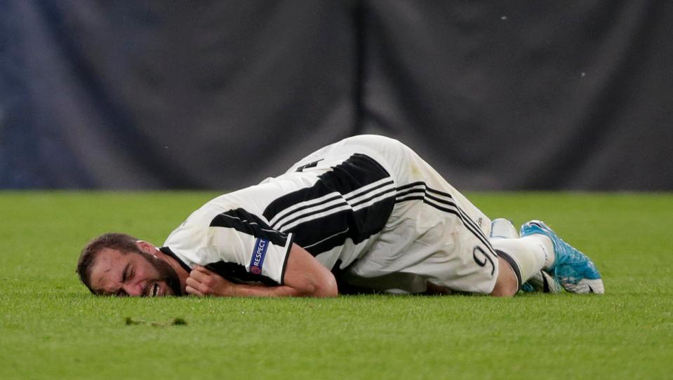 Juventus forward Gonzalo Higuain lays in agony after a challenge from Kamil Glik