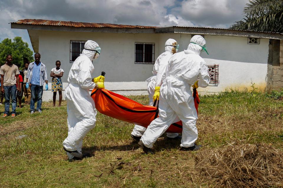 A Liberian Red Cross burial team retrieves the body of a suspected victim of Ebola in Banjor, on the outskirts of Monrovia, in 2014