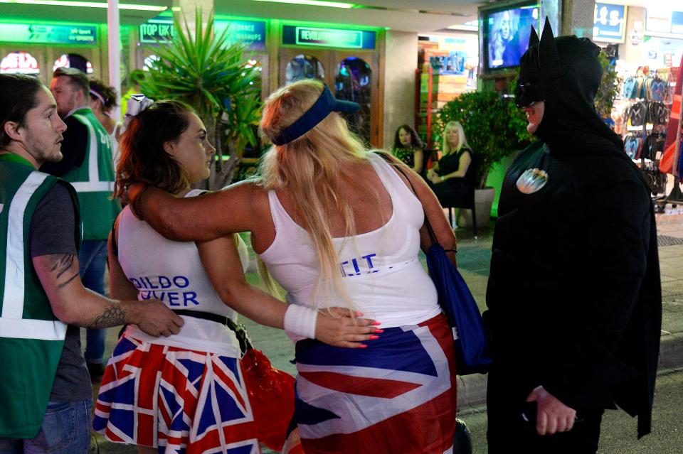  Batman chats with women dressed in Union Jacks as they are led away by resort staff