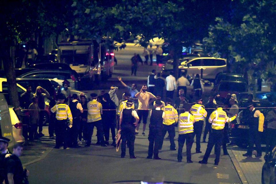 Police stand at the cordon after the road was closed to traffic amid the chaos