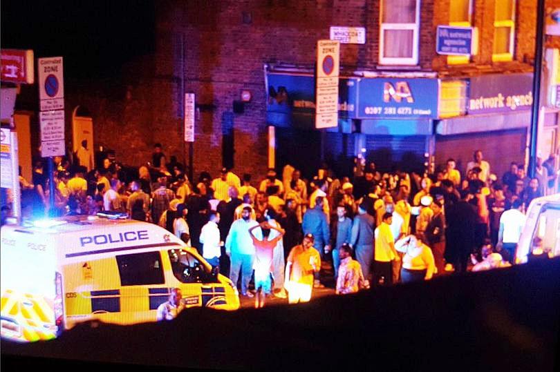 Dozens of people can be seen gathered on the junction close to Seven Sisters Road where the incident happened