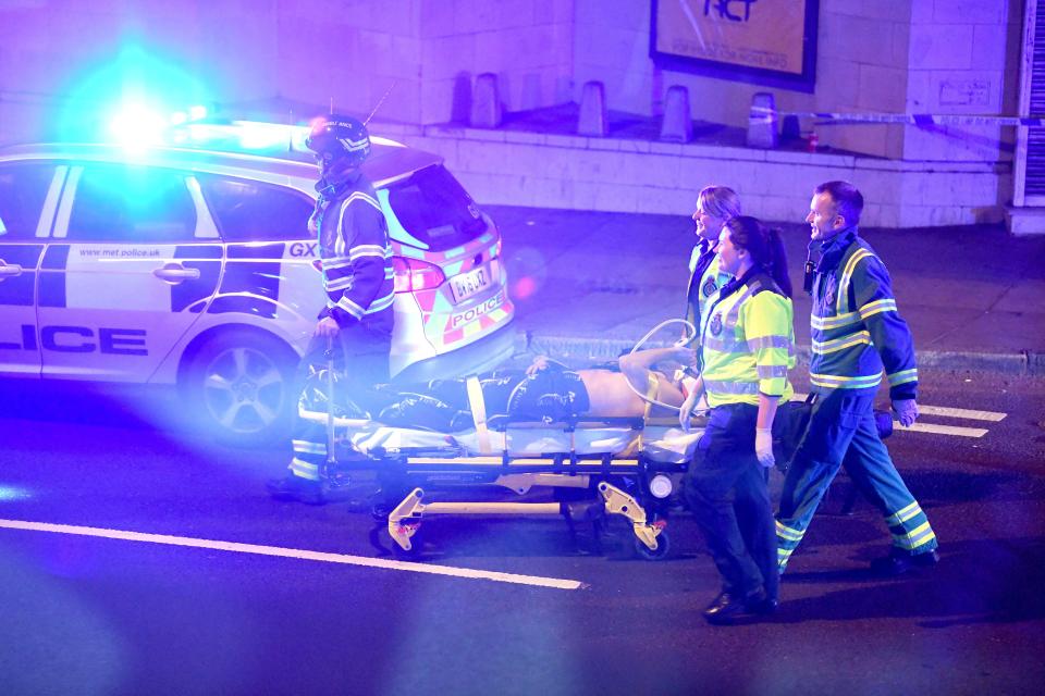 An injured pedestrian is taken away by paramedics on a stretcher after a van hit people close to a mosque in North London