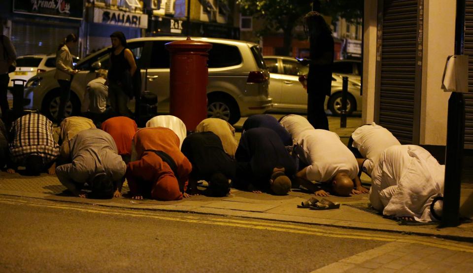  Muslims pray on a pavement clost to the mosque after a van hit pedestrians