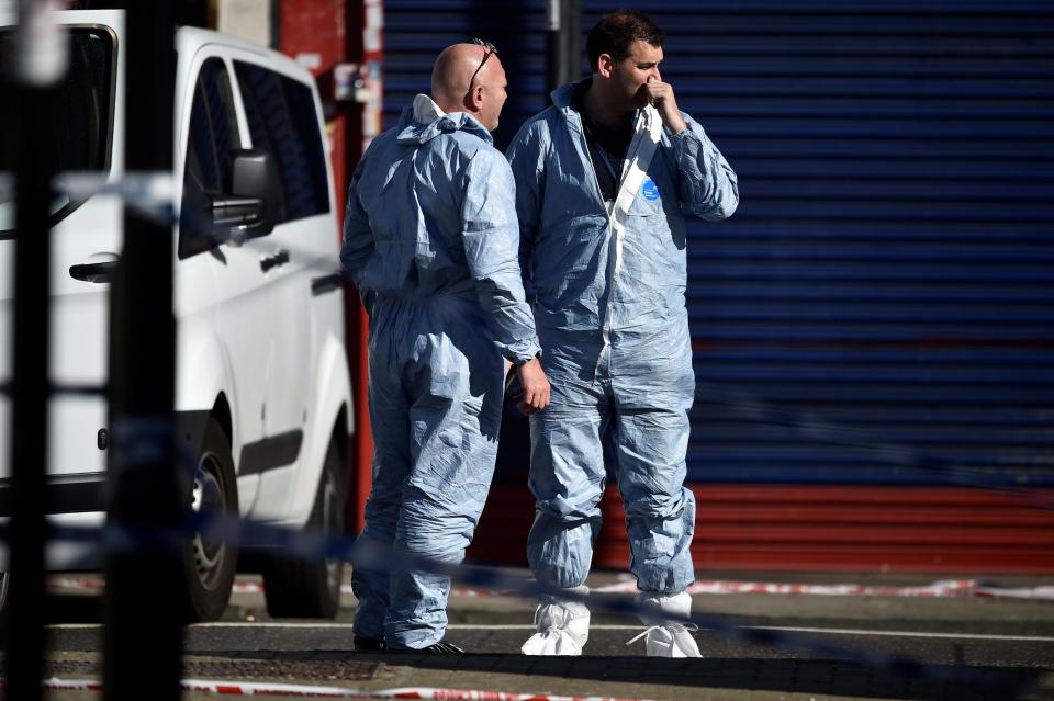  Forensic investigators stand behind cordon tape at the scene of an attack where a man drove a van at Muslim worshippers outside a mosque