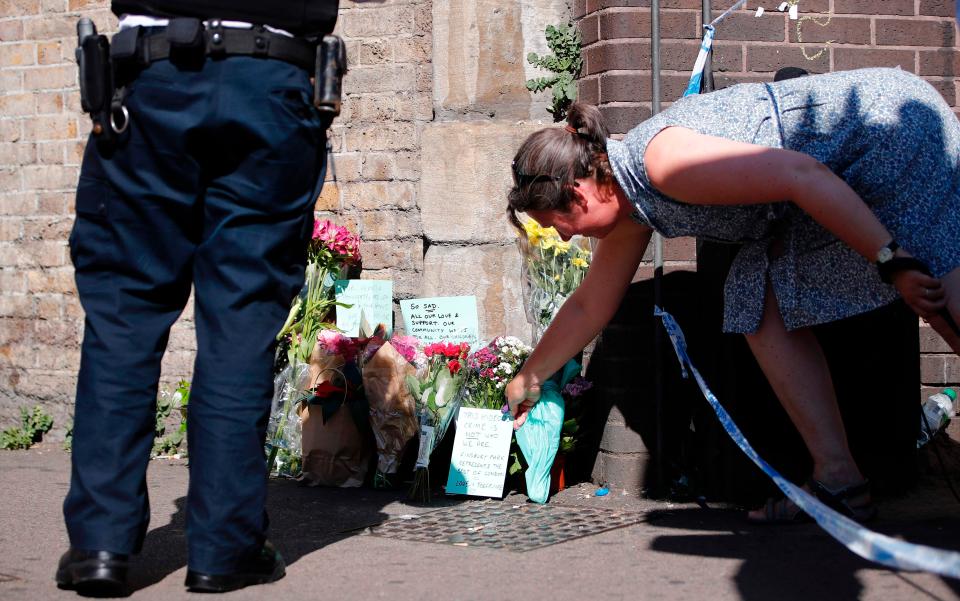  A woman lays flowers at a police cordon near the scene in Finsbury Park this morning