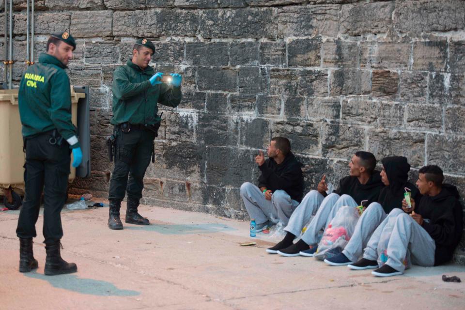 A Spanish Civil guard takes pictures of some of the men rescued