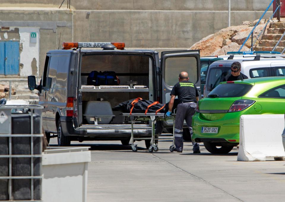 Officials take away the body of an Algerian migrant who died during the crossing
