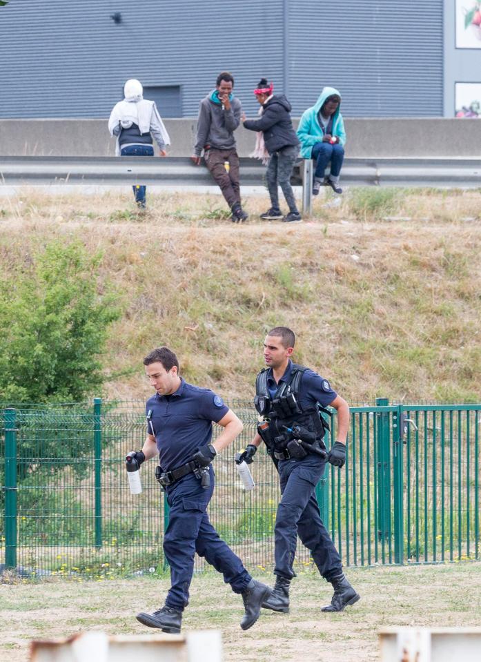  Migrants run from police on a motorway near the Calais port