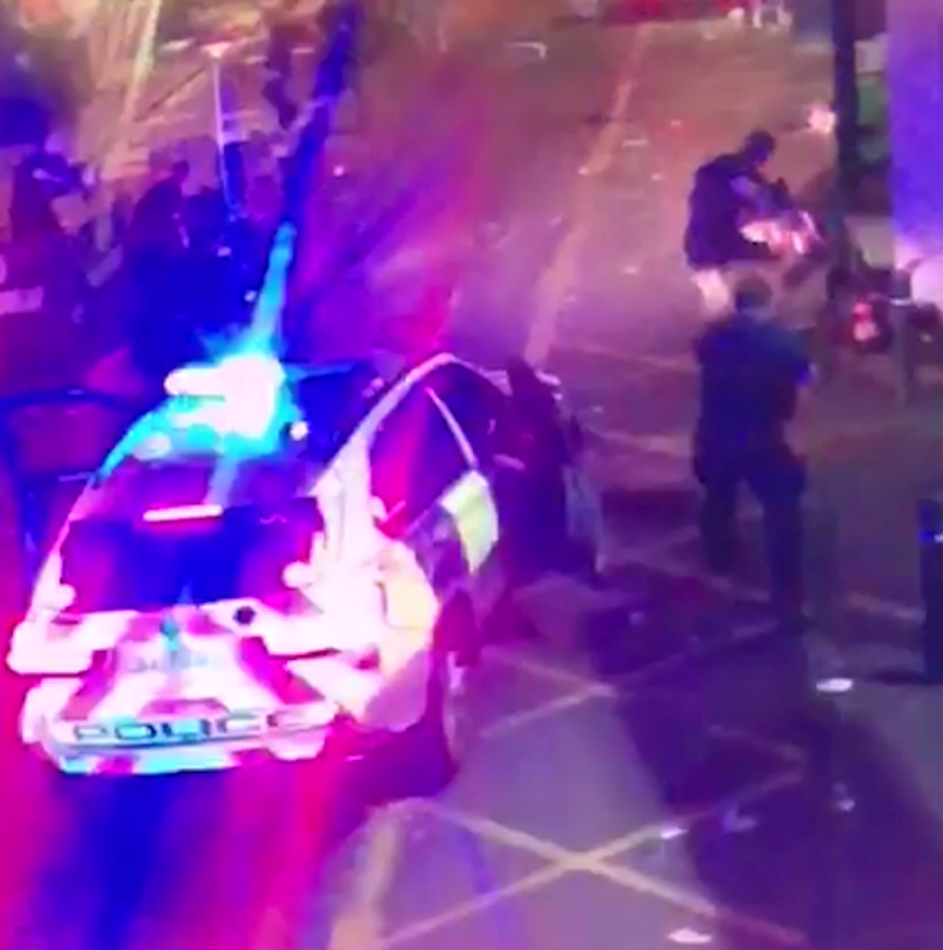 As one of the terrorists lies on the floor, an officer points a gun at the suspect and kicks him to ensure he is no longer a threat