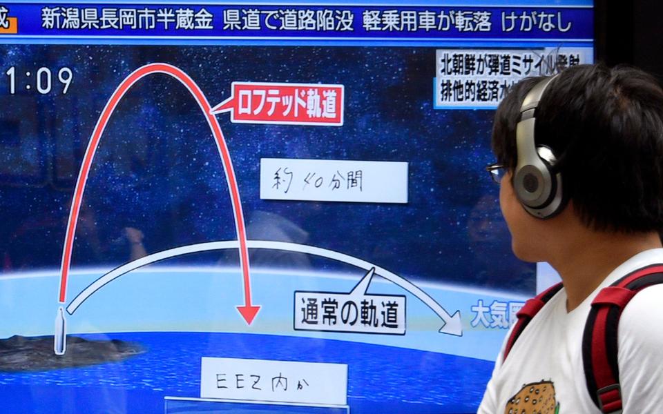  A pedestrian looks at a TV screen on a street broadcasting news of North Korea's missile launch, in Tokyo, Japan