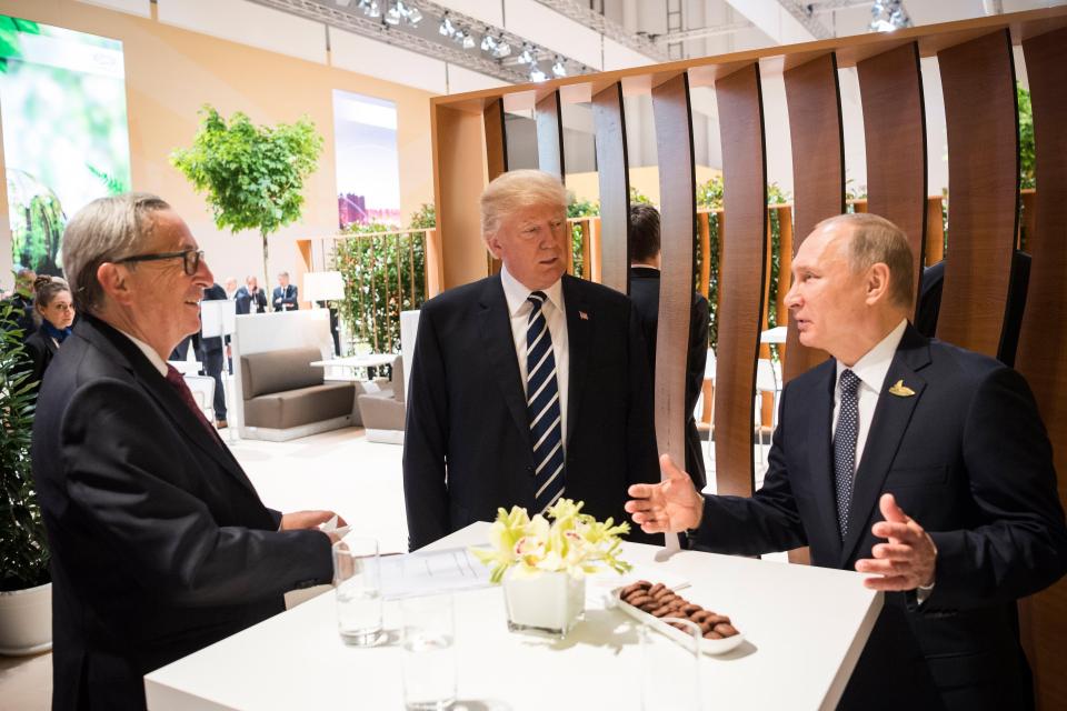  The US President pictured chatting with Putin and Jean Claude Juncker