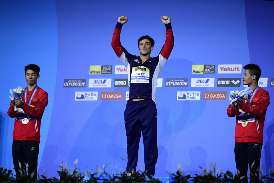  Tom Daley proudly stood with a gold medal on the podium