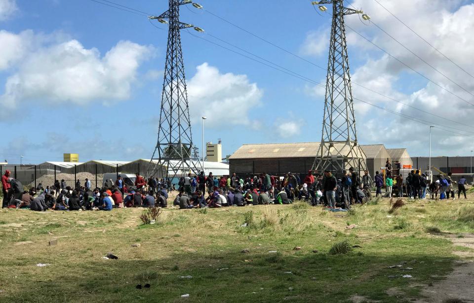  Crowds of migrants wait for handouts at a new settlement yards away from the notorious Calais Jungle