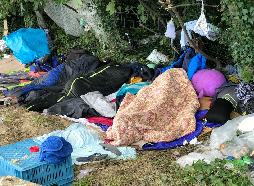  Migrants sleep with their possessions tied to a fence