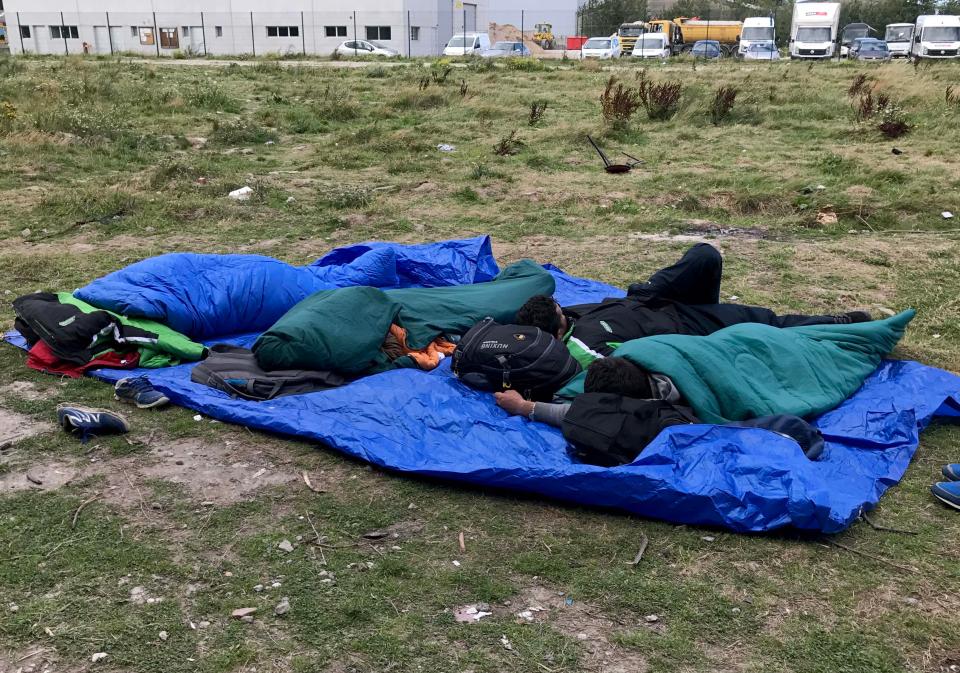  Migrants sleep rough on grassland in Calais