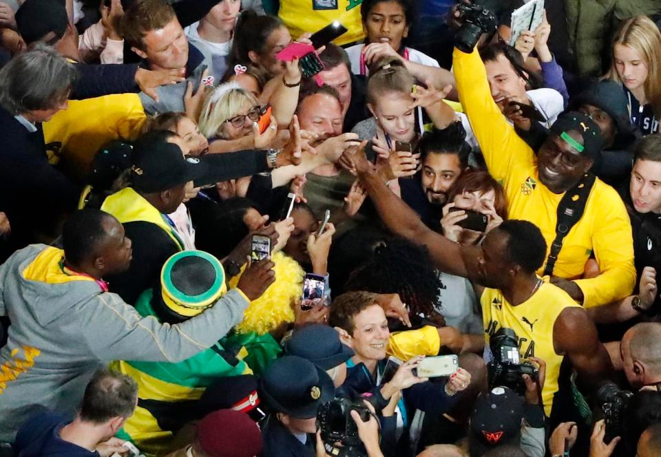 Usain Bolt is mobbed by his adoring fans after taking bronze in the 100m