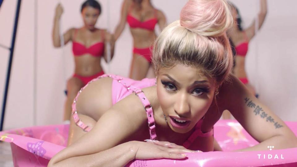  Nicki Minaj jiggles her booty and seductively writhes in a paddling pool wearing a pink latex bikini in her red hot new music video Rake It Up