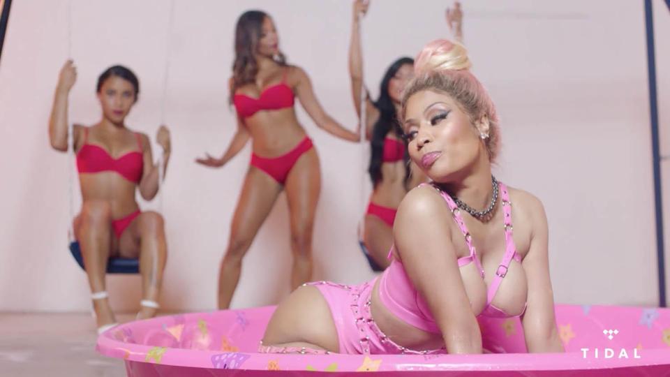  The rapper is backed by three beauties in red bikinis sitting on a swing