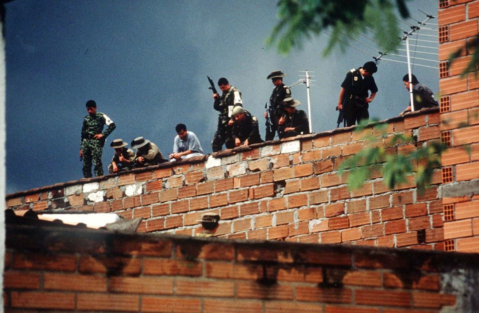  Armed soldiers patrol the walls of the building Pablo Escobar is evading capture