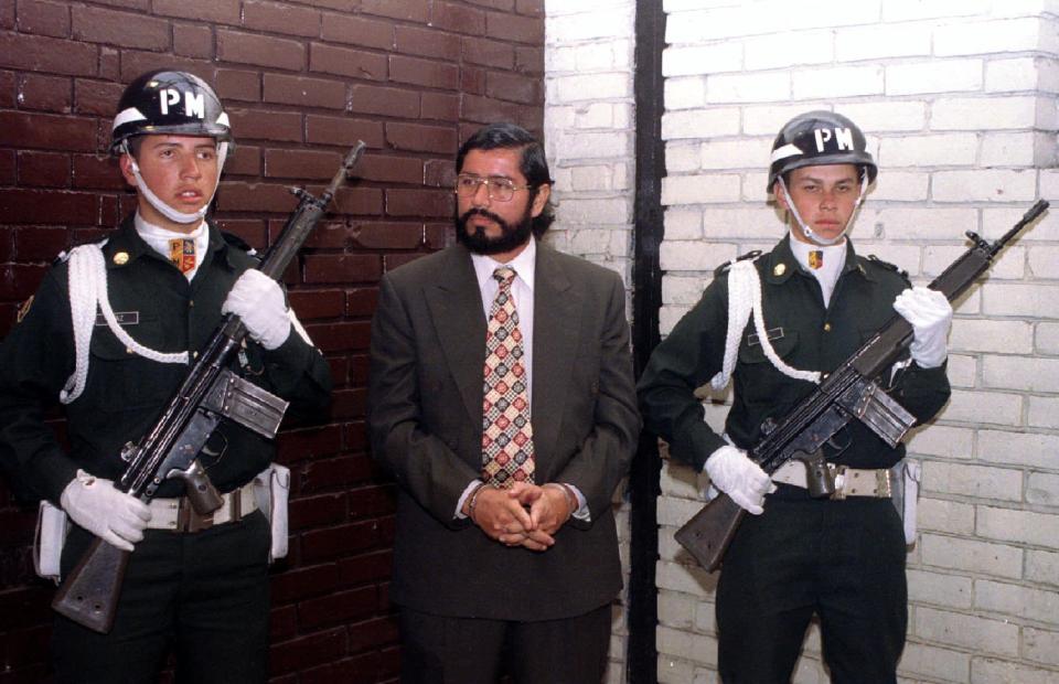  Cali drug cartel leader Victor Julio Patino Fomeque stands handcuffed between two guards at a military police base in Bogota