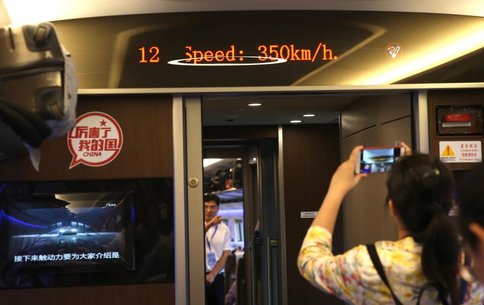 A passenger photographs the speed on the on board display showing 350 kph (217 mph)