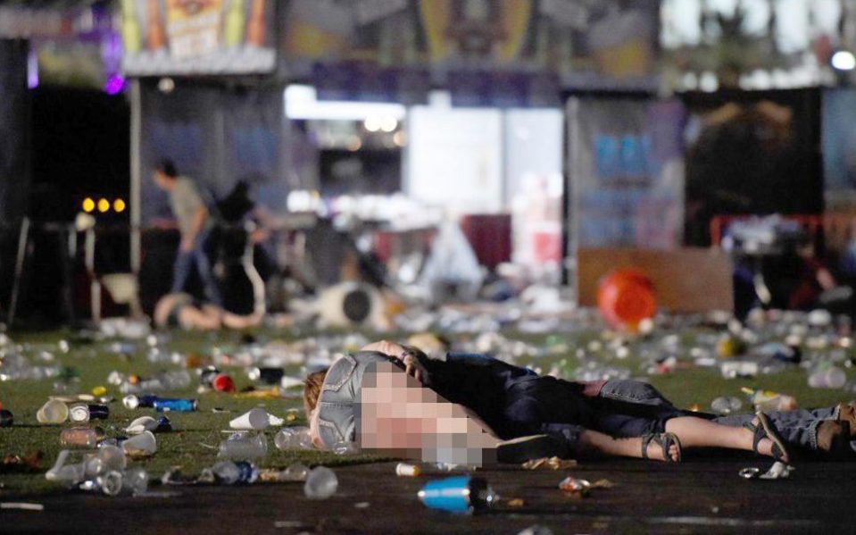 A woman lies on the ground, covered in blood