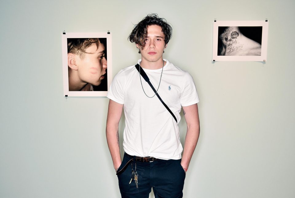 Brooklyn Beckham posing with some of the shots shared in his What I See book