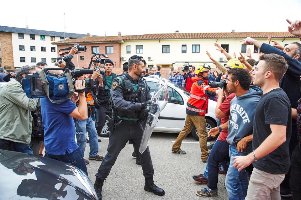 Firefighters can be seen urging protesters back away from police 