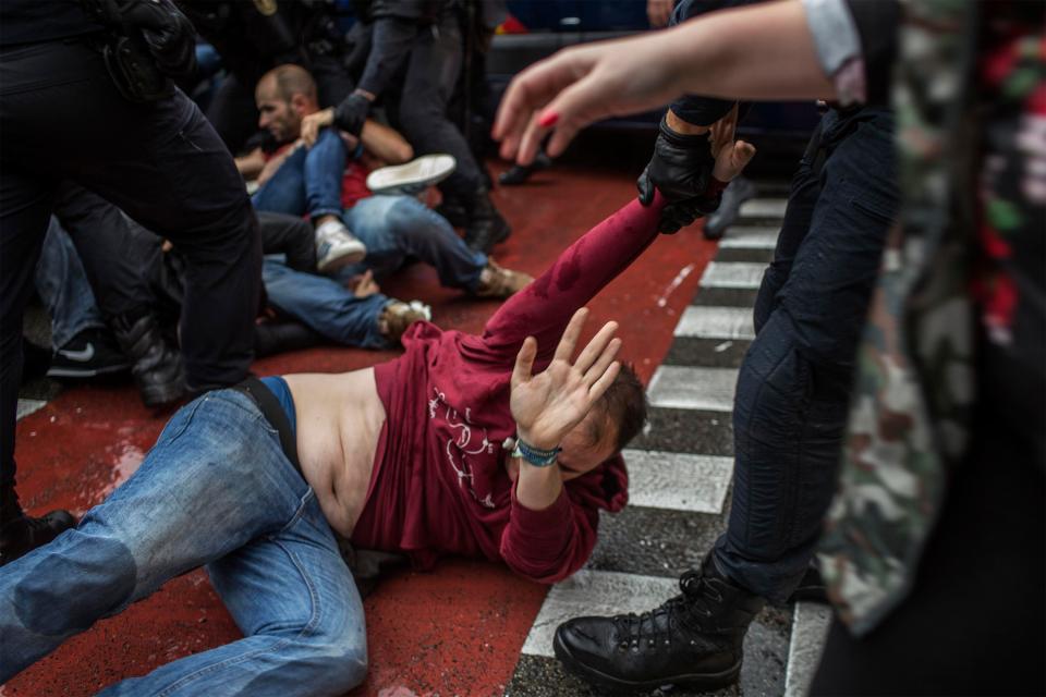 A demonstrator cowers on the floor amid clashes with police 